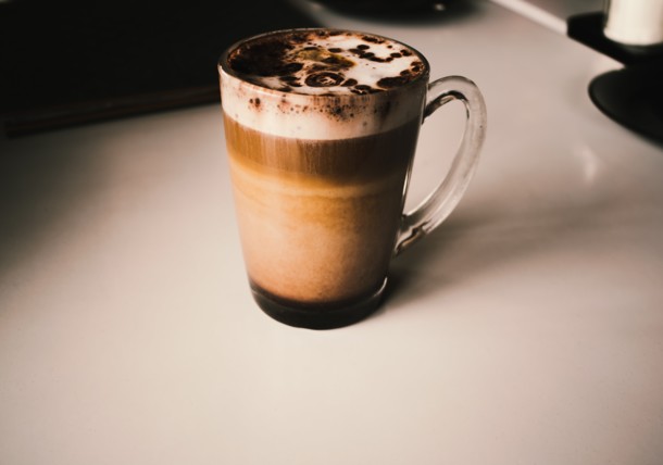 Tazza cappuccino con arte del caffè sul tavolo del caffè di strada