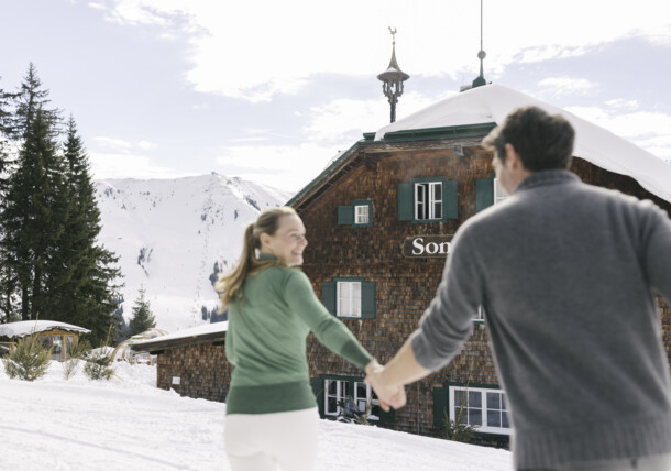     Couple in motion at ski hut, Kitzbühel winter 